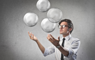 Businessman juggling with some air bubbles